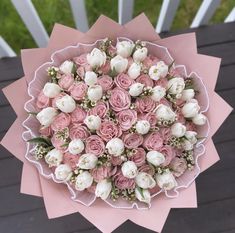 a bouquet of pink and white flowers sitting on top of a table