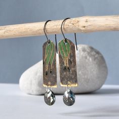 Earrings made of silver and brass. Brass dyed chocolate brown, raw, with rubbing showing the golden color of brass. The engraved outlines of the leaves shine in the light. The green finish, is crowned with drops of very dark green, falling almost into black. The bottom of the earrings is decorated with Swarovski teardrops in gray.  The earwires are made of 925 sterling silver. The length of the brass pendant is about 3.5 cm (ca. 1.38in). The width is about 1.5 cm (ca. 0.59in). Swarovski teardrop Silver Patina Drop Earrings, Silver Brass Earrings With Patina, Silver Drop Earrings With Patina, Patina Metal Earrings As A Gift, Patina Drop Earrings As Gift, Metal Earrings With Patina For Gift, Brown Electroformed Brass Earrings, Bronze Long Drop Earrings For Gift, Bronze Patina Earrings For Gift