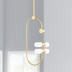 a modern chandelier hanging from the ceiling in a room with white walls and windows