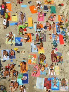 many people are laying on towels at the beach