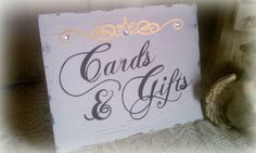 a wooden sign that says cards and gifts on it next to a figurine