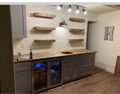 a kitchen with an island and built - in wine cooler, lights on the ceiling