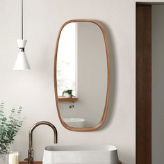 a bathroom sink sitting under a mirror next to a wooden cabinet and light fixture on the wall