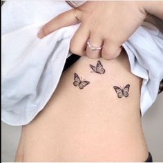 a woman's stomach with three butterflies on her side and the bottom part of her belly