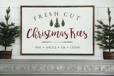 a sign that says fresh cut christmas trees on the front of a fireplace mantel