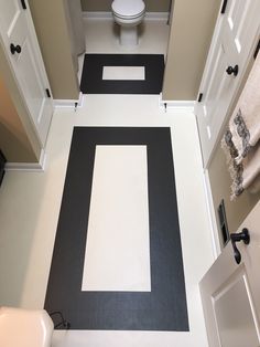 a white toilet sitting next to a black and white floor