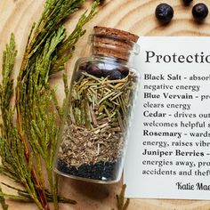 a jar filled with herbs next to a note on a wooden surface and surrounded by berries