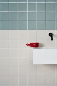 a red cup sitting on top of a white sink