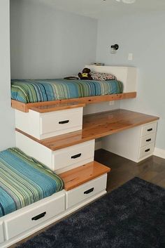 there are two beds with drawers under the stairs in this room, and one is on top of the other bed