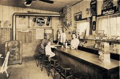 an old photo of some people sitting at a bar