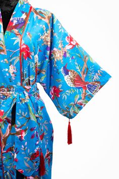 A stunning Birds of Paradise print kimono. With a number of colours to choose from, you will be spoilt for choice The fabric is easy to clean and easy to wear. The soft cotton, gentle material and luxurious drape, whether you're lounging or layering, this kimono cover up will make you feel like a queen. It also has 4 beautiful handmade tassels, 2 on the sleeves and 2 on the belt, making this a Limited Edition. With a loose swing shape for an easy, flowy fit makes this robe extremely comfortable and elegant to wear. The print covers the entire front and back panel and is piped in a lovely contrast colour. Use the belt included with the dress if you prefer a more fitted look. Our kimono comes in 4 sizes and 3 lengths, Size: *SMALL will fit size UK 8-12 /US 4-8 . Width is 120cm. Will fit up t Patterned Wrap Kimono With Print, Patterned Printed Wrap Kimono, Blue Summer Kimono For Home, Patterned Kimono For Loungewear, Summer Home Kimono With Kimono Sleeves, Summer Blue Kimono For Home, Blue Floral Print Beach Robe, Blue Floral Print Wrap Kimono, Blue Summer Sleepwear With Kimono Sleeves