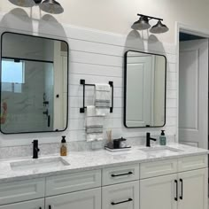 a bathroom with two sinks and three mirrors