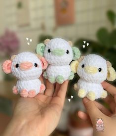 three small crocheted animals are held up in the air by someone's hand