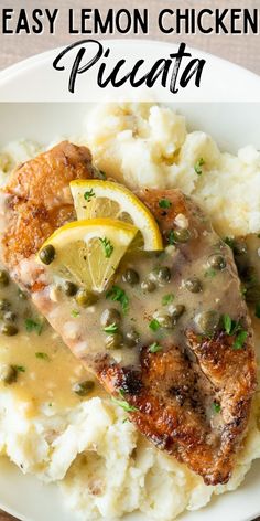 a white plate topped with meat and potatoes covered in gravy next to a lemon wedge