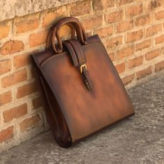 Our briefcase is the key item that every professional needs in order to carry either papers or electronic devices. You can create a unique and personal article to match your wardrobe as well as your profession by combining the different materials available. Its dimensions are 13 x 16.5 x 2 inches / 33 x 42 x 5 cm. THE DETAILS: Materials: cognac burnished painted calf Lining: brown fabric A unique savoir-faireAll our bags & leather goods are handmade in Spain —current artisans for the most recogn Luxury Men's Rectangular Cases, Luxury Men's Satchel For Daily Use, Luxury Brown Men's Luggage, Luxury Cognac Bags With Magnetic Closure, Luxury Modern Cases With Leather Lining, Luxury Italian Craftsmanship Briefcase For Business, Luxury Single Compartment Bags For Fall, Trendy Luxury Single Compartment Box Bag, Luxury Men's Formal Briefcase