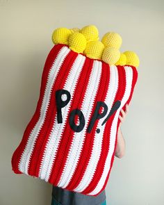 a person wearing a red and white striped knitted bag with poop written on it