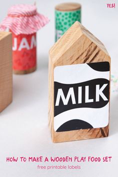 a wooden play food set with the words milk printed on it and three sprinkles next to it