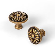 two antique brass cabinet knobs on white background