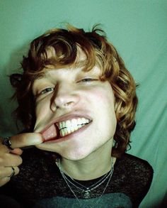 a young man making a silly face while brushing his teeth