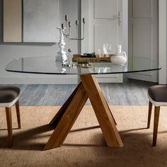 a glass table with wooden legs in a room