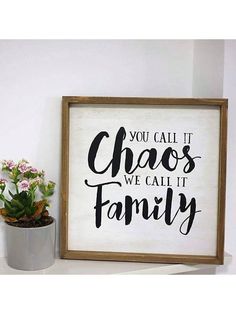 a sign that says you call it chaos we call it family next to a potted plant