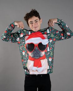 a young man is wearing a christmas sweater with a pug wearing sunglasses and a santa hat