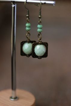 Unique boho earrings with light green czech glass faceted 10 mm, small green glass beads, antique brass square charms and antique brass earring hooks. Earring hooks are from nickel free and lead free metal. Unique jewelry for your boho outfit or a great gift for someone special! *The total lenght of earrings is about 51 mm including earring hooks. Other earrings of my shop you can see here: https://www.etsy.com/shop/NaTavelli?section_id=13757927  Thanks for visit. Vintage Brass Beaded Earrings For Gifts, Vintage Brass Beaded Earrings Gift, Green Bohemian Beaded Brass Earrings, Multicolor Dangle Beaded Brass Earrings, Green Czech Glass Drop Earrings, Green Earring, Boho Jewelry Diy, Earrings Square, Boho Outfit