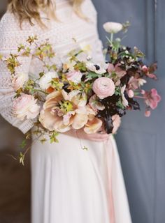 a woman holding a bouquet of flowers in her hands