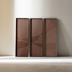 three wooden panels sitting next to each other on a floor in front of a wall