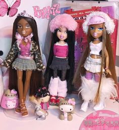 three dolls are standing next to each other in front of a pink box with butterflies on it