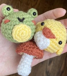 two small crocheted stuffed animals are held in someone's hand