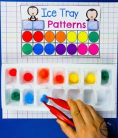 a hand holding a pair of scissors next to an ice tray pattern