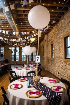 a table set up with plates and napkins for a birthday party at a brick building