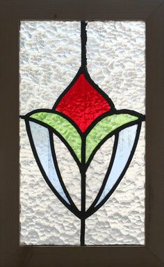 a close up of a stained glass window in a door with white and red designs