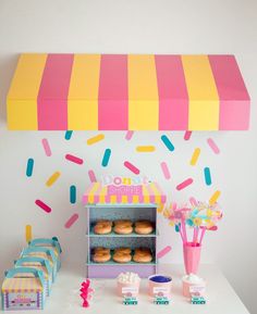 a donut shop is decorated with sprinkles and pink, yellow, and blue