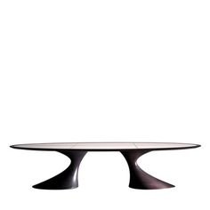 an oval glass table with black legs and a white top, against a white background