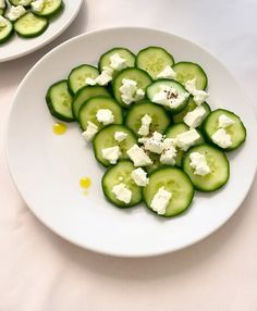 cucumbers and cottage cheese are on a white plate, ready to be eaten