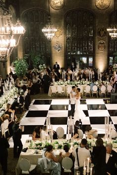 a wedding reception in an old building with chandeliers