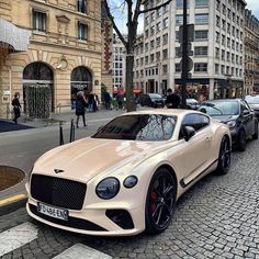 a white car parked on the side of a street next to other cars and people