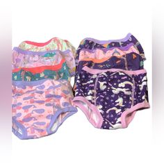 three baby diapers are lined up in different colors and patterns, one is pink, the other is blue