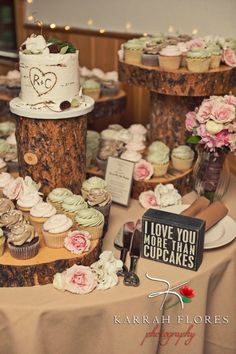 a table topped with lots of cupcakes covered in frosting next to cakes