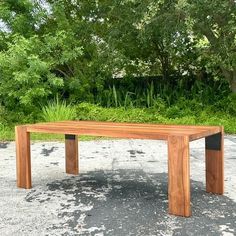 a wooden table sitting on top of a gravel field