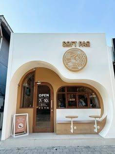 the front entrance of a restaurant with tables and benches