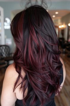 Woman with long, wavy brown hair with red highlights in a hair salon. Medium Brown Purple Hair, Deep Cherry Red Balayage, Dark Roots With Red Ends, Light Brown Hair Burgundy Highlights, Red Thick Highlights, Brunette Hair With Burgundy Highlights, Light Red Highlights On Dark Hair, Dark Red Hair With Blonde Highlights Balayage, Cherry Red Hair Styles