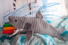 a crocheted shark laying on top of a bed