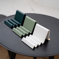 three pieces of plastic sitting on top of a black table with white and green trim