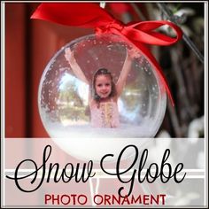 the snow globe photo ornament has a red ribbon on it