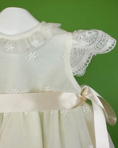 An adorable and delicate off-white dress for baby girls to wear on a special day. It is made with an embroidered french tulle. It has buttons on the back for closure and comes with a matching bonnet. Made in Spain Inside: 65% polyester 35% cotton Dry Clean Final sale, no exchanges nor returns are accepted Cream Ruffled Dress For Baptism, Cream Dress With Ruffles For First Communion, Embroidered Tulle Dress For Ceremonies, Fitted Embroidered Dress For First Communion, Embroidered Fitted Dress For First Communion, Fitted Floral Embroidery Baptism Dresses, Cream Tulle Dresses With Lace Bodice, Cream Tulle Dress With Lace Bodice, Cream Ruffled Baptism Dress For Dress-up