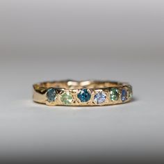 a gold ring with different colored stones on it