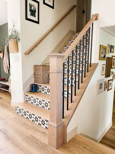 the stairs are decorated with black and white tiles on them, along with pictures hanging on the wall